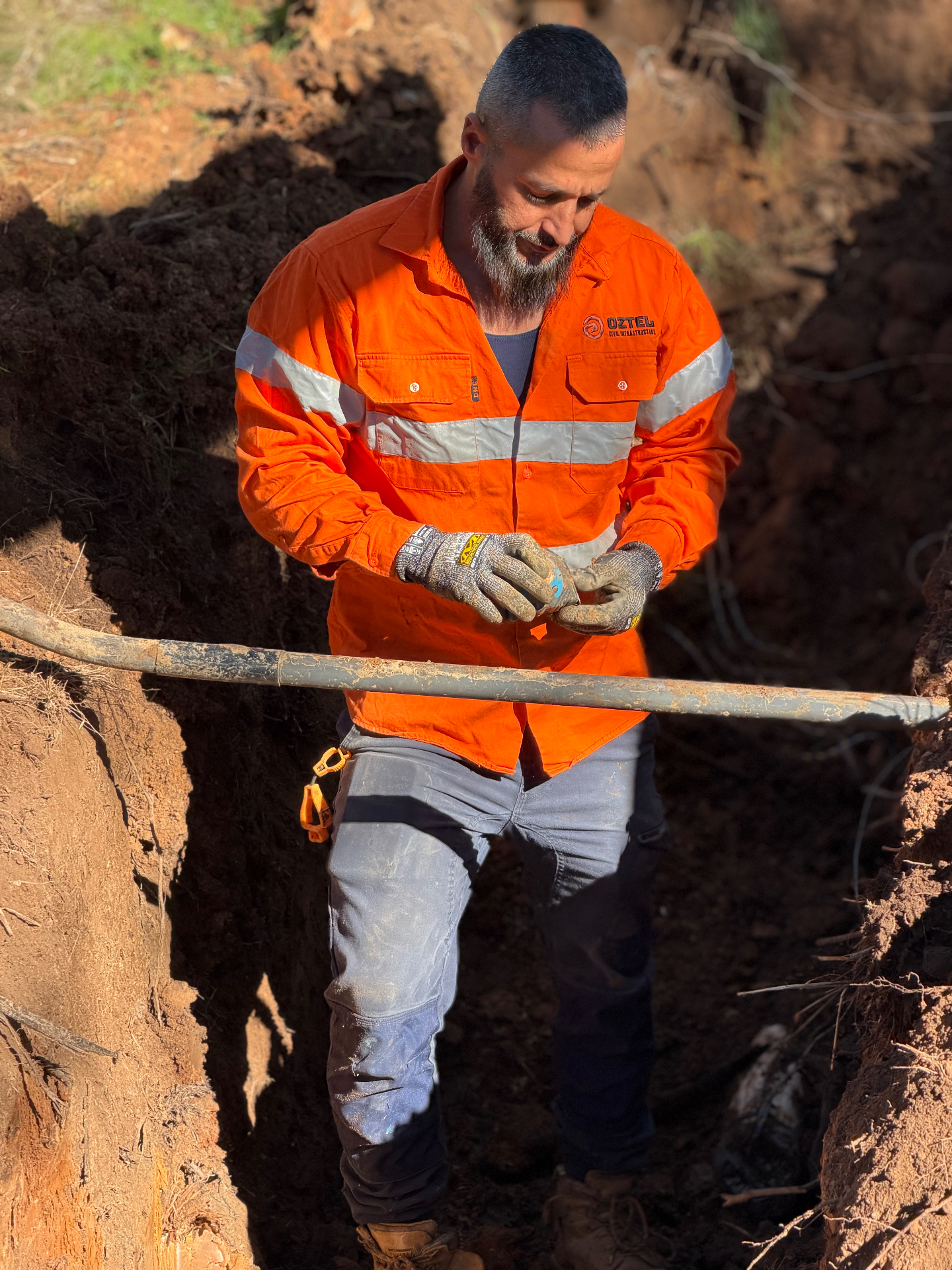 OZTEL civil infrastructure crew installing telecommunications conduit on a NSW job site